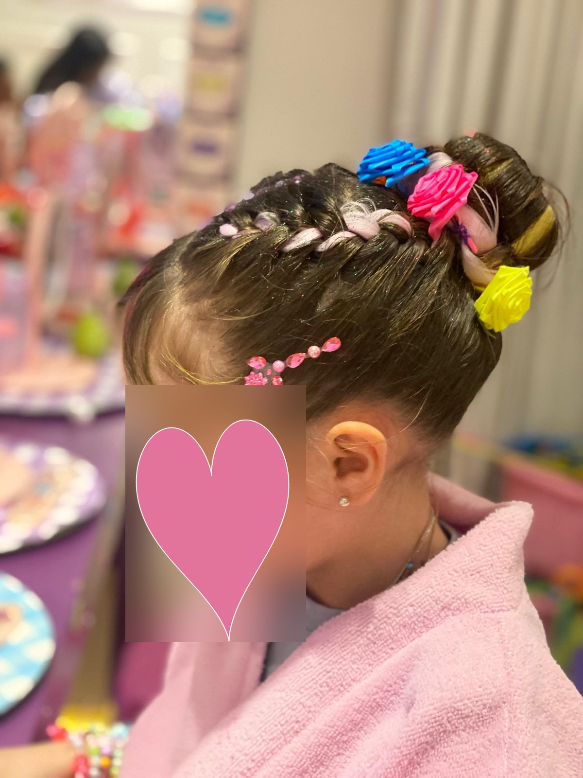 Niña con bata rosa y accesorios de spa en el cabello